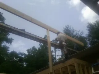 Carpenter setting a ridge beam over a new addition frame — Ice Dam Removal by Roofing Brothers in Krotz Springs