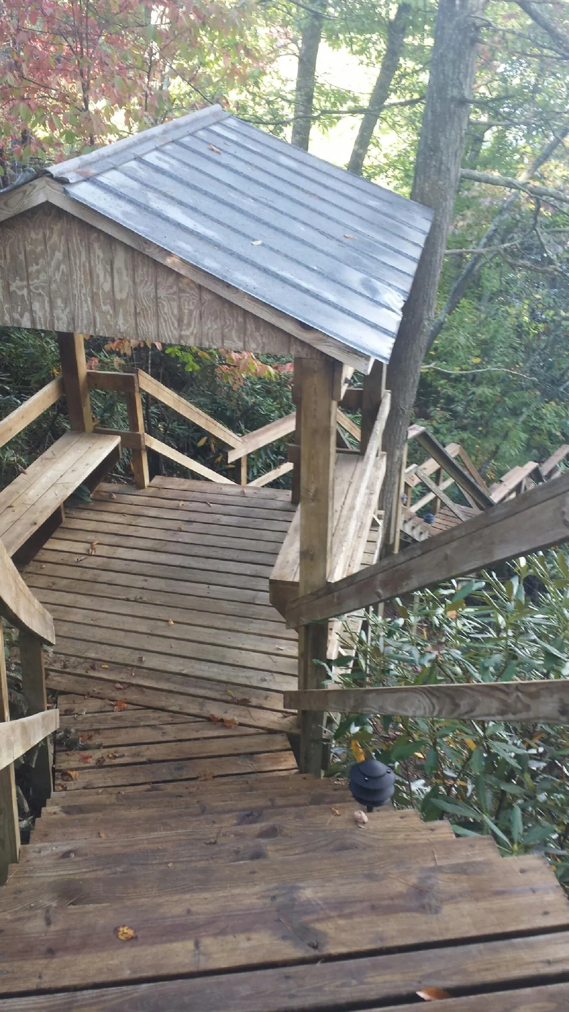 Metal roofed shelter over wooden steps on a wooded walkway — Skylight Repair & Installation work by our crew in Krotz Springs