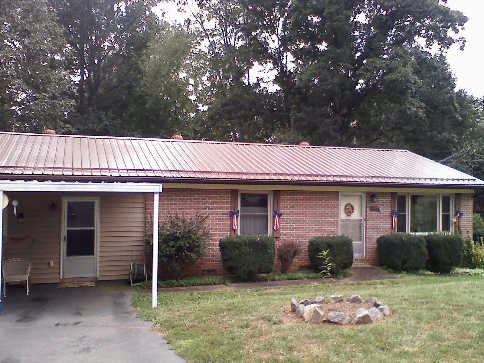 Bronze metal roof and carport on a brick ranch home — Roof Repair work by our crew in Krotz Springs