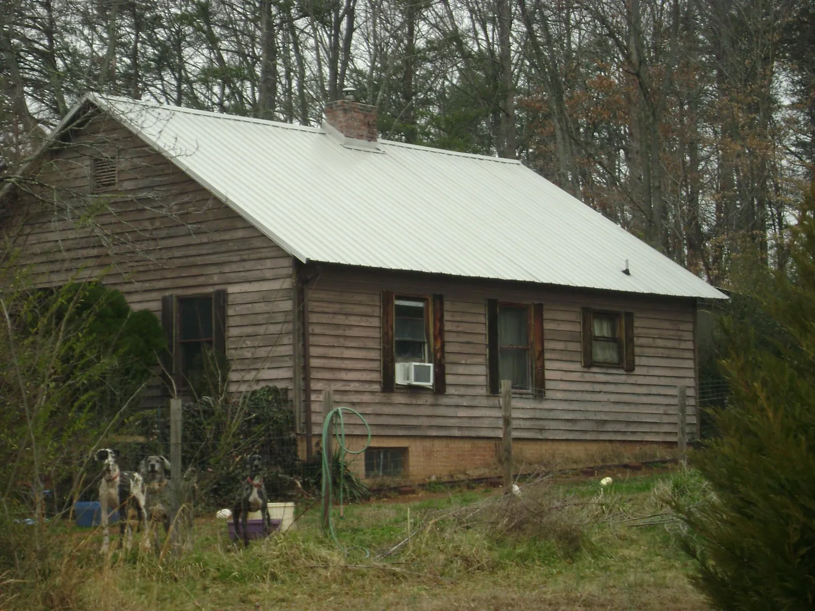 White metal roof on an old wood sided farmhouse, from a Asphalt Shingle Roof Repair job in Krotz Springs